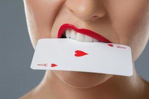 mulher com lábios vermelhos e carta na boca foto