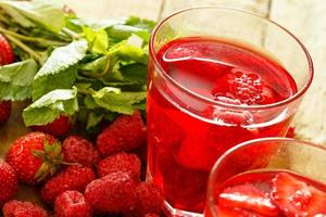 bebida refrescante com framboesa e morango na mesa de madeira foto