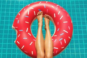 pernas femininas e anel de natação inflável em forma de rosquinha foto