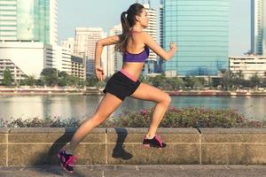 mulher na cidade durante seu treino de corrida foto