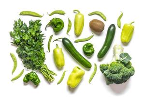 vegetais verdes, frutas, pimentas, pepinos, feijões, salsa, brócolis, kiwi, isolado no fundo branco, vista superior, conceito de alimentação saudável, comida de fazendas orgânicas locais foto