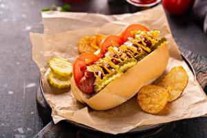 cachorro-quente com tomate, mostarda e picles foto