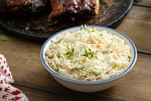 salada coleslaw servida com refeição de churrasco, acompanhamento tradicional foto