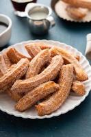 churros caseiros com açúcar de canela em um prato foto