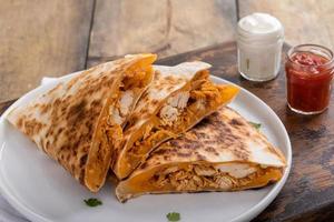 cheddar e quesadillas de frango cortadas em fatias em um prato foto