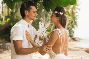 casal recém-casado está comemorando seu casamento na praia foto