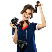 mulher em look vintage segurando câmera e filme fotográfico em suas mãos foto