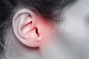 closeup da orelha feminina com fonte de dor foto