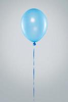 um balão azul isolado em fundo cinza foto