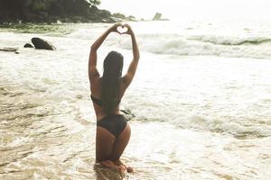 mulher vestindo traje de banho e relaxando na praia tropical foto
