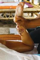 closeup de pés femininos durante a tradicional massagem tailandesa foto