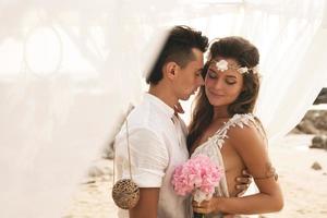 casal feliz está comemorando seu casamento na praia na ilha tropical foto