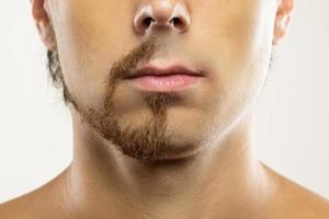 rosto de homem com barba parcialmente raspada. foto