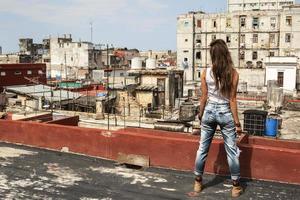 mulher no telhado de prédio antigo em havana foto