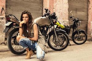 modelo de mulher está posando ao lado de motocicletas antigas foto