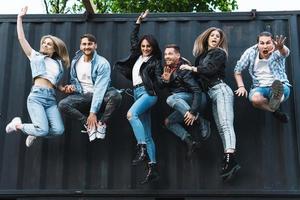 grupo de jovens e elegantes pulando no ar foto