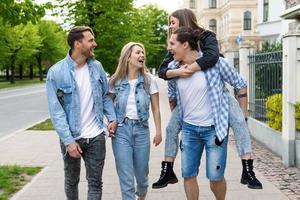 grupo de melhores amigos está se divertindo enquanto caminhava pela rua da cidade foto