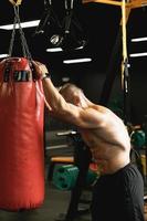 lutador cansado durante seu treino com um saco de pancadas foto