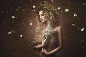 linda jovem com penteado afro e maquiagem linda com muitas flores brancas foto