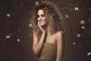 linda jovem com penteado afro e maquiagem linda com muitas flores brancas foto