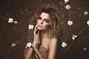 linda jovem com penteado afro e maquiagem linda com muitas flores brancas foto