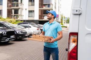 correio durante a entrega de pizza está esperando por um cliente foto