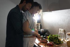 jovem casal cozinhando um saboroso jantar juntos em uma cozinha foto