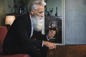 homem sênior barbudo bonito bebendo vinho tinto foto