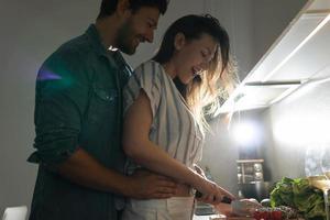 jovem casal cozinhando um saboroso jantar juntos em uma cozinha foto