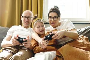família feliz está jogando videogame em casa foto