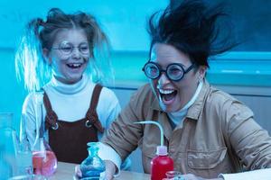 professora e garotinha durante aula de química misturando produtos químicos em um laboratório foto