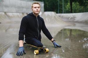 jovem deficiente com um longboard em um skatepark foto