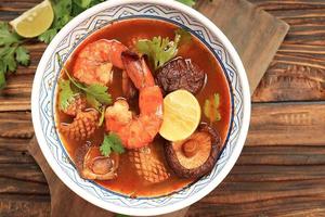 tom yam kung, sopa de camarão e limão vermelho com lulas e cogumelos foto