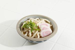 macarrão kake udon japonês em uma tigela sobre fundo branco foto