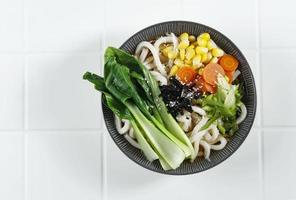 udon com vegetais, conceito udon saudável. na mesa branca foto