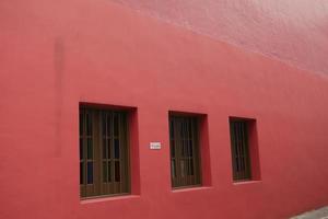 janelas de cor vintage na parede vermelha em edifícios foto