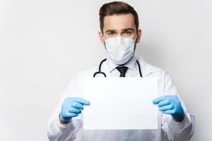 médico está segurando uma folha de papel branco em branco foto