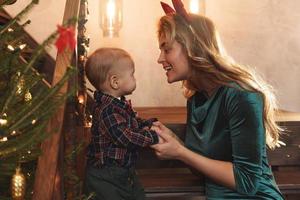 mãe feliz e seu lindo filho estão comemorando o natal ou o ano novo. foto