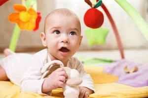 bebê fofo está brincando no tapete de atividades foto