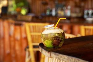 bebida de coco na mesa em autêntico bar de praia foto