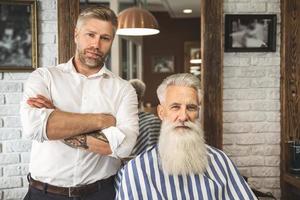 cabeleireiro feliz e cliente na barbearia foto