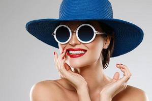 linda mulher usando chapéu azul e óculos de sol está pronta para férias foto