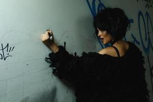 mulher esquisita no túnel escuro com graffiti foto