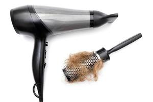 secador de cabelo e escova com um pedaço de cabelo foto