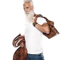 homem sênior barbudo bonito com bolsa de couro e jaqueta em fundo branco foto