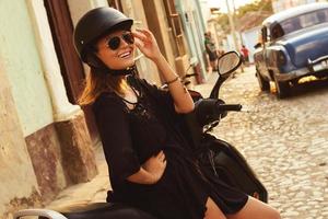 mulher dirigindo scooter pelas ruas da cidade velha foto