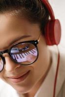 jovem compositora com um reflexo das teclas de piano em um óculos foto