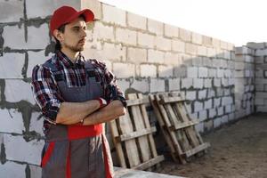 homem pedreiro profissional no canteiro de obras foto