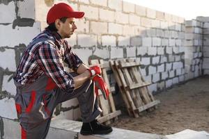 homem pedreiro profissional no canteiro de obras foto