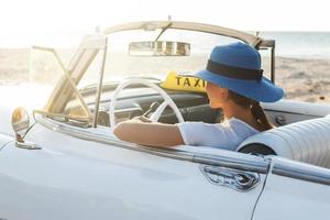 mulher jovem feliz e carro conversível retrô foto